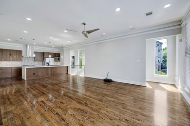 Open concept living with wood floors, high ceiling