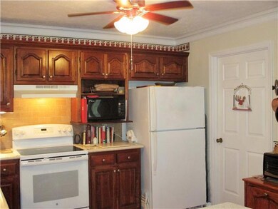 More work space and cabinetry on this side with the new 5-burner stove (2013), microwave and refrigerator. Door leads to a convenient laundry room with a large pantry.