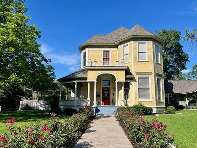 Victorian house with covered porch, a front lawn,