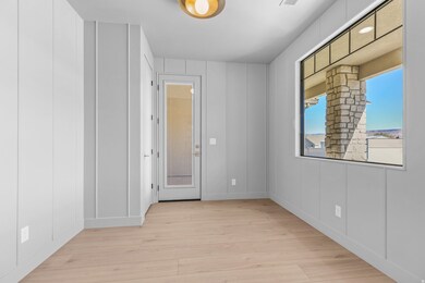 Unfurnished room featuring light wood-style floors and a decorative wall