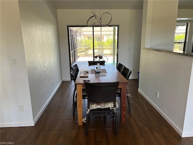 Dining area with dark wood-type flooring and a chandelier