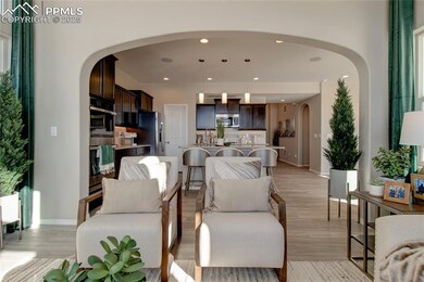 Living area with arched walkways, light wood-style floors, and recessed lighting