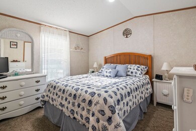 Carpeted bedroom featuring crown molding, vaulted 