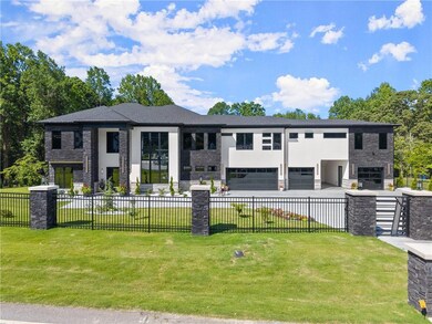 View of front of home featuring stone siding, an attached garage, stucco siding, and driveway
