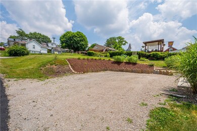 Large parking area and the mostly flat back yard.