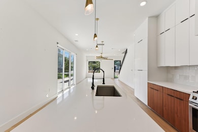 Kitchen featuring modern cabinets, a sink, tastef