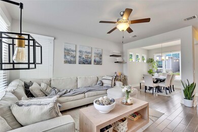 Living room featuring ceiling fan with notable ch