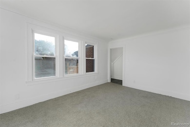 Carpeted spare room with baseboards and ornamental molding