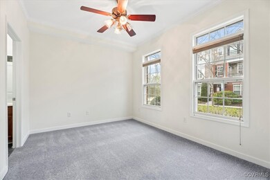 Carpeted empty room featuring a ceiling fan, ornam