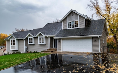 The front of this home reveals the elevation of the large lot and oversized double garage and driveway with off street parking for several vehicles.  Notice the fenced in area next to the garage which would make a large outdoor kennel for pets.