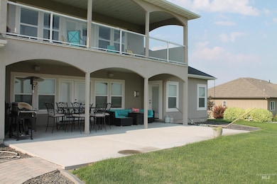 Rear view of property with a balcony, a patio area, outdoor lounge area, and a lawn