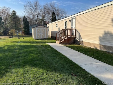 View of grassy yard with a storage unit