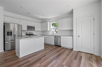Kitchen featuring stainless steel appliances, white cabinetry, and light wood-type flooring