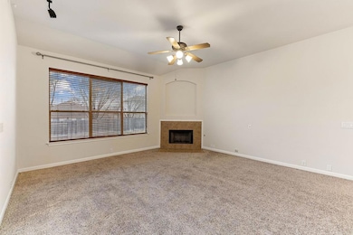 Unfurnished living room with light carpet, a fireplace, ceiling fan, and lofted ceiling