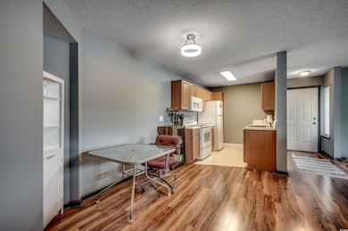 Kitchen with sink, white appliances, a textured ce