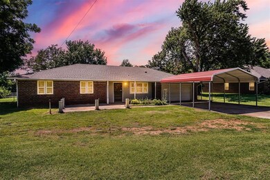 Single story home featuring a lawn and a carport