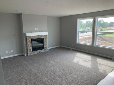 This spacious living gathering area seamlessly connects to the kitchen area, perfect for entertaining. It also features many large windows providing warm natural light.(Model photo)