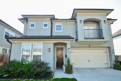 The light-toned exterior is accented by elegant tr