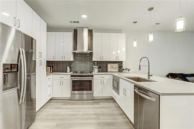 Kitchen featuring visible vents, wall chimney ran