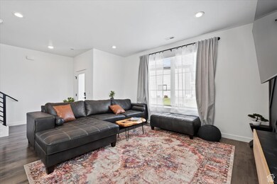 Living area with stairs, dark wood-style flooring, and recessed lighting