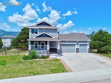View of front of property featuring a garage, covered porch, concrete driveway, stone siding, and a shingled roof