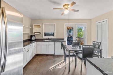 Kitchen with stainless steel fridge, french doors, white dishwasher, sink, and white cabinets