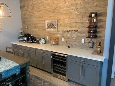 Indoor dry bar with beverage cooler and wooden wal