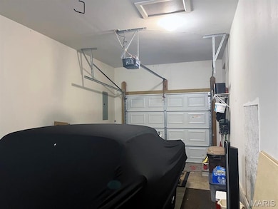 Garage featuring electric panel and a garage door opener