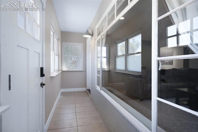 Doorway to outside with baseboards and tile patter