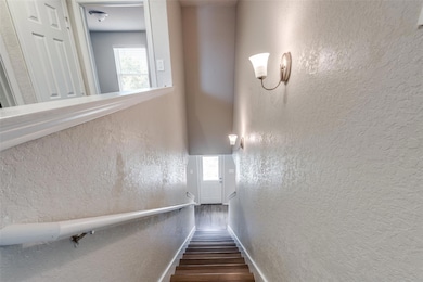 Stairway with baseboards, wood finished floors, a