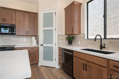 Kitchen featuring dishwasher, sink, decorative bac