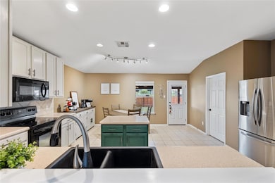 Kitchen featuring black appliances, backsplash, light tile patterned floors, light countertops, and recessed lighting