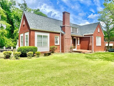 Rear view of property with brick siding, a shingle