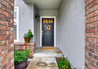 Welcoming entry with brick faÃ§ade and upgraded light fixture ~