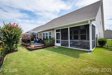 Rear yard showcasing enclosed patio and deck.