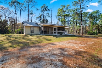 Back of property with a yard and a sunroom