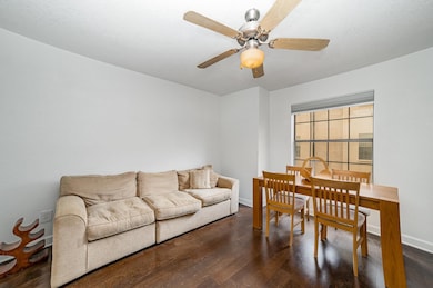 Living room featuring baseboards, a ceiling fan, a