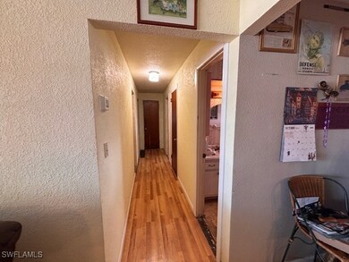 Hallway featuring a textured ceiling and light har