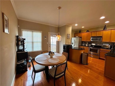 Dining space with ornamental molding, light wood finished floors, and recessed lighting
