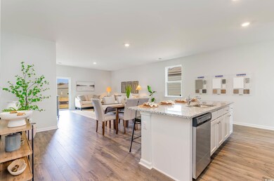 Kitchen with a sink, stainless steel dishwasher, an island with sink, white cabinetry, and light wood finished floors