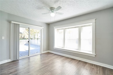 Dining room featuring a textured ceiling, light wood-style floors, and ceiling fan