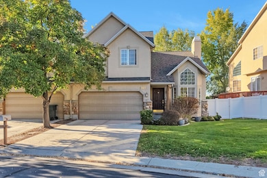 Traditional home featuring roof with shingles, stone siding, concrete driveway, a chimney, and stucco siding