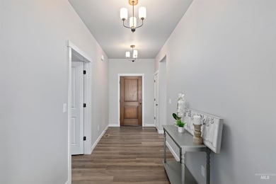 Entryway with wood finished floors and a chandelier