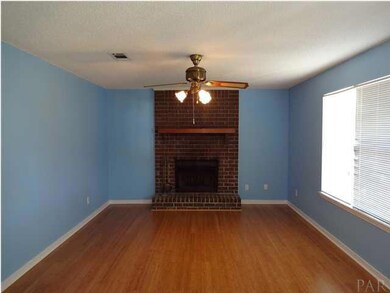 View of wood burning fireplace in living room
