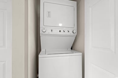Washroom featuring stacked washer / drying machine