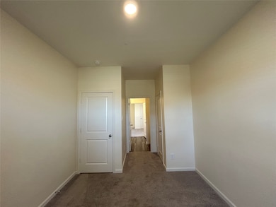 Hall with dark colored carpet and baseboards
