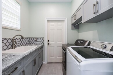 The laundry room features designer cabinets, a was