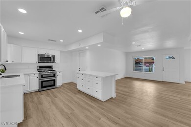 Kitchen with a sink, recessed lighting, light wood
