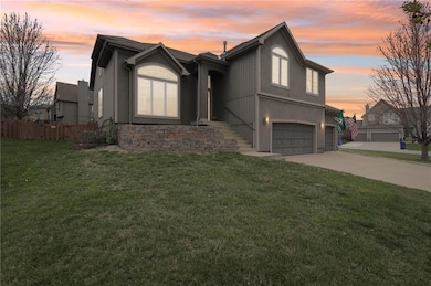 View of front of property featuring concrete driveway, stucco siding, fence, a garage, and a yard