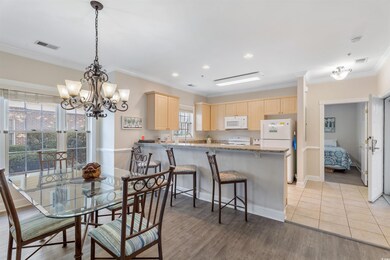 Dining room with light wood-type flooring, crown m